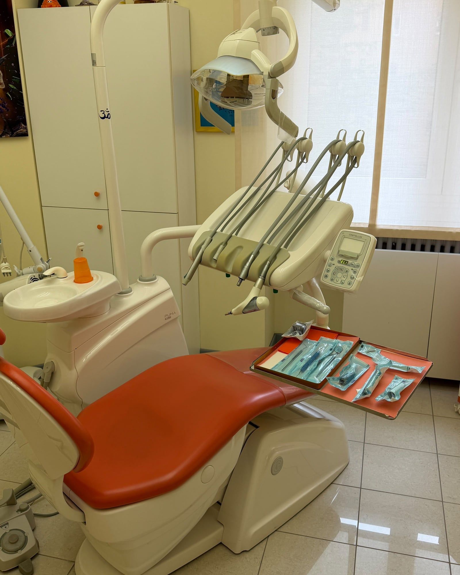 La sala dell'igiene dello studio, con la poltrona arancione e gli strumenti sterili pronti sul vassoio