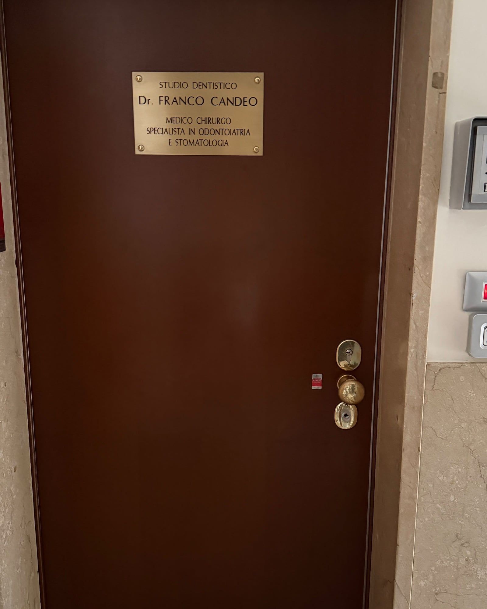 La porta dello studio al secondo piano, con la targa del Dr. Franco Candeo