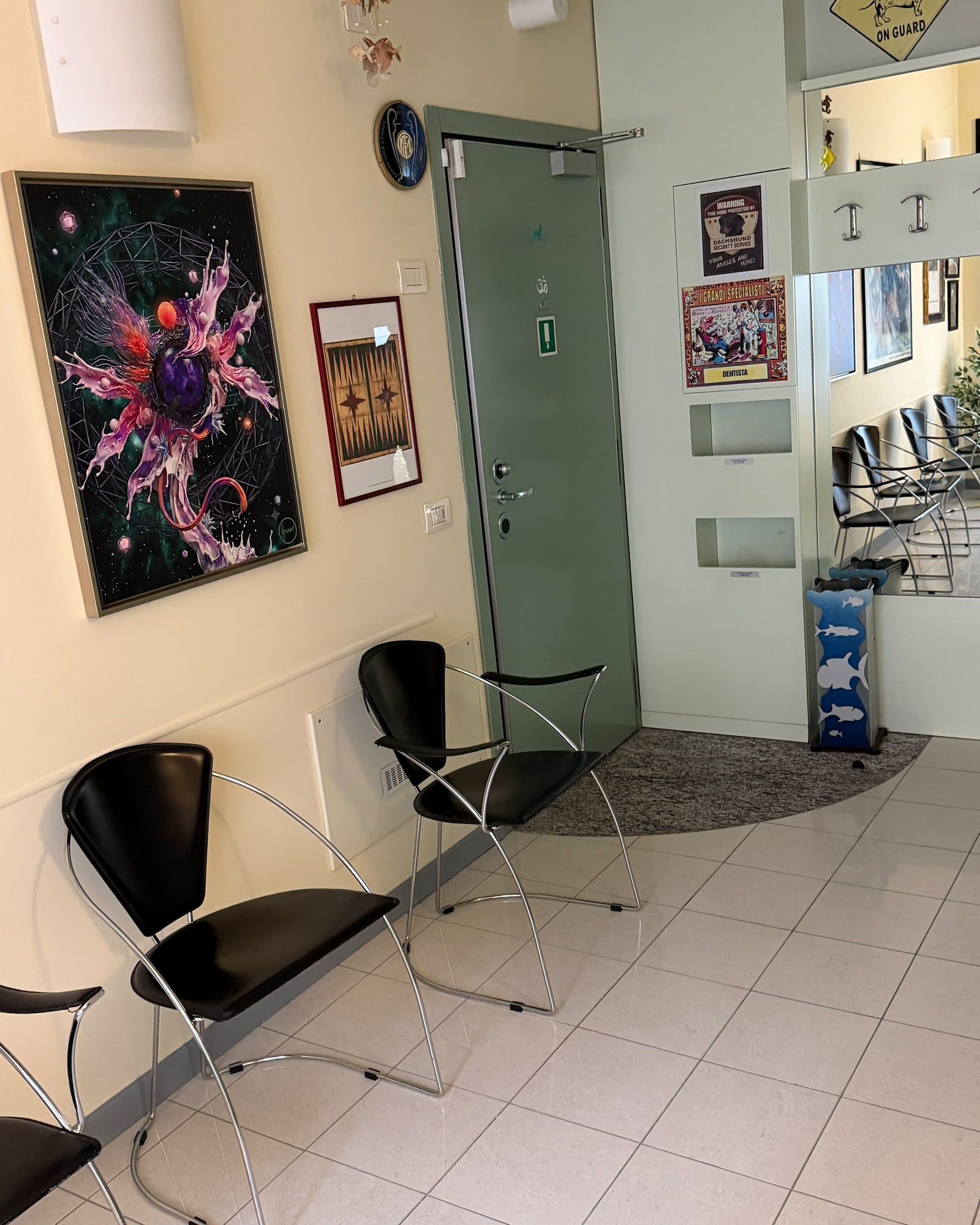 La sala d'attesa dello studio, con le sedute nere e i quadri alle pareti